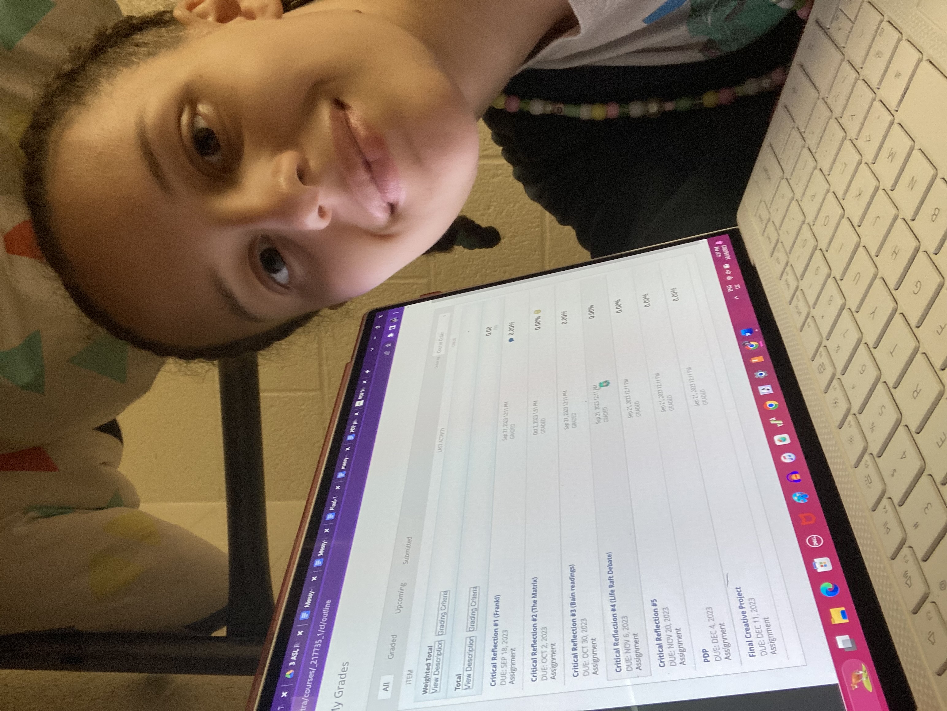 Selfie of Gabrielle with her computer which displays BlackBoard grades for Honors 300 of all 0%