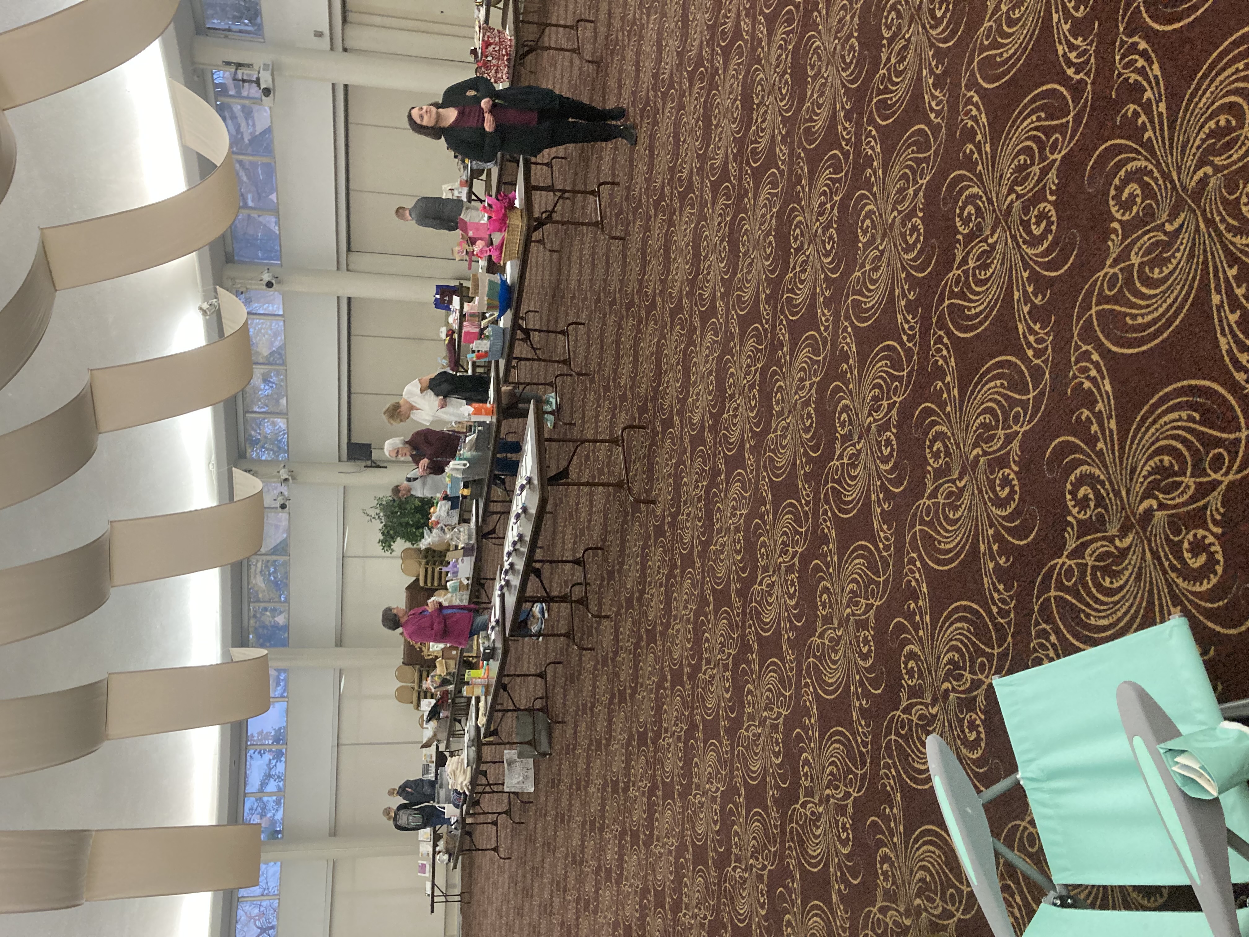 Photo of honors auction there are several tables with various items on them and several people are walking around